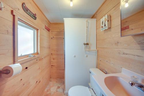 a bathroom with a sink and a toilet and a window at Stone Lake Cabin with Private Deck and Fire Pit! in Northwoods Beach