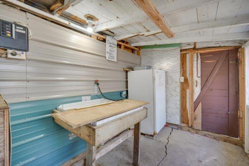 a room with a sink and a refrigerator and a door at Stone Lake Cabin with Private Deck and Fire Pit! in Northwoods Beach