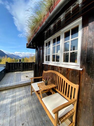 a patio with two benches and a table on a building at Three bedroom holiday house with jacuzzi in Bjorli , pets allowed in Bjorli