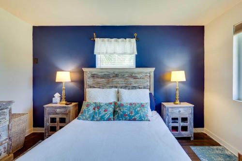 a blue bedroom with a bed with two lamps at West Palm Beach Home with Fenced-In Yard and Deck! in West Palm Beach