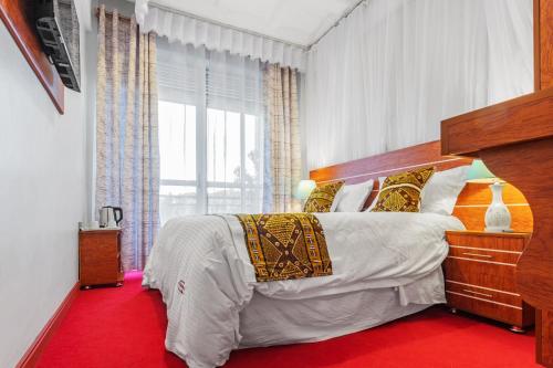 a bedroom with a large bed and a red floor at Ambrosia Heights in Entebbe