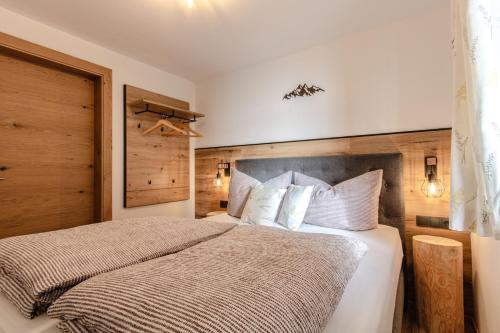 1 dormitorio con 1 cama grande con almohadas blancas en Leitenhof Fam.Steger, en Uttendorf