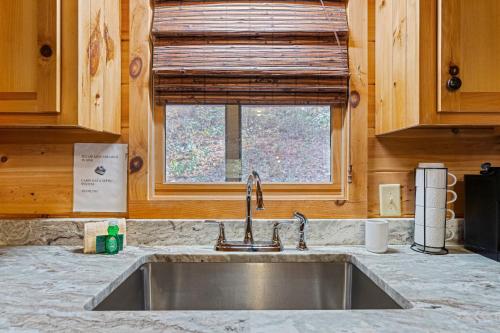 eine Küchentheke mit einem Waschbecken und einem Fenster in der Unterkunft BigFoot Bluff in Hood