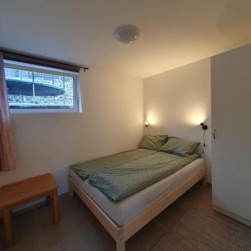 a small bedroom with a bed with a window at Ramfjord Apartment in Tromsø