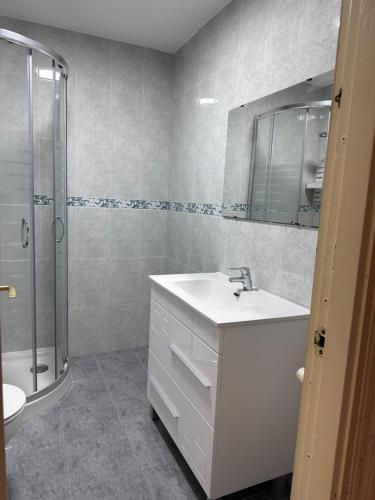 une salle de bain blanche avec lavabo et douche dans l'établissement Passeig Maritim, à Miami Platja