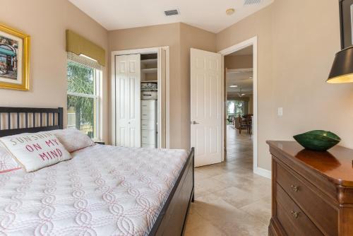 a bedroom with a bed and a dresser and a hallway at Luxury Cearra Del Ray Townhome Seconds to Beach 2-Car Garage in New Smyrna Beach