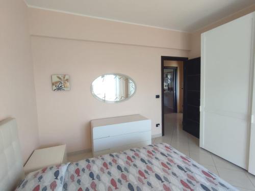 1 dormitorio con cama y espejo en la pared en B&B Dolce Risveglio, en Boissano
