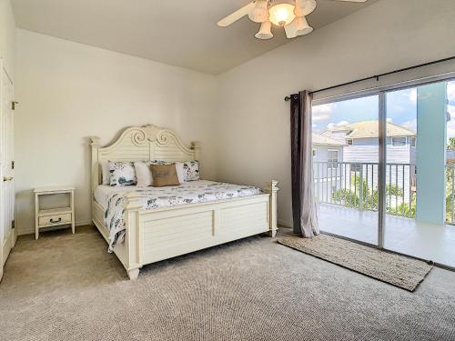 1 dormitorio con cama y ventana grande en Salt Life Pool Home ~ Ocean Views ~ Walk to Flagler Avenue ~ 604S, en New Smyrna Beach