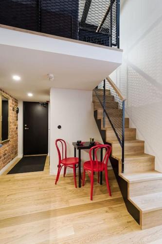 ein Esszimmer mit zwei roten Stühlen und einem Tisch in der Unterkunft Loft Black and Red in Tallinn