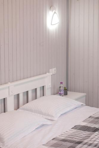 a bedroom with a white bed and a lamp at Sonna in Pidzakharychi