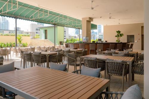 an empty restaurant with wooden tables and chairs at Waymore Hotel Spa & Casino in Panama City