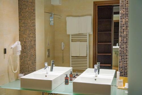 a bathroom with two sinks and a large mirror at Kipi Mountain Resort in Kipoi