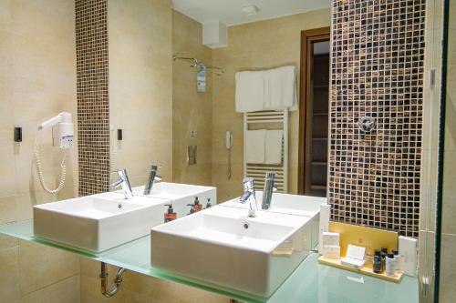 a bathroom with two sinks and a mirror at Kipi Mountain Resort in Kipoi
