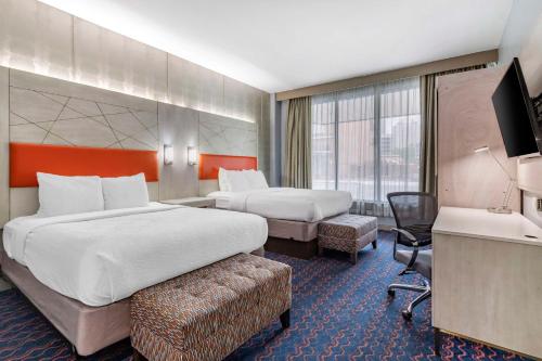 um quarto de hotel com duas camas e uma televisão em Best Western Premier Historic Travelers Hotel Alamo/Riverwalk em San Antonio
