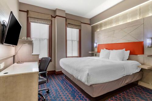 Habitación de hotel con cama grande y escritorio. en Best Western Premier Historic Travelers Hotel Alamo/Riverwalk en San Antonio