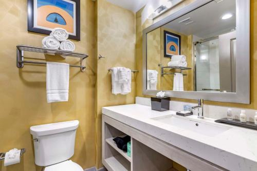 a bathroom with a sink and a toilet and a mirror at Best Western Premier Historic Travelers Hotel Alamo/Riverwalk in San Antonio