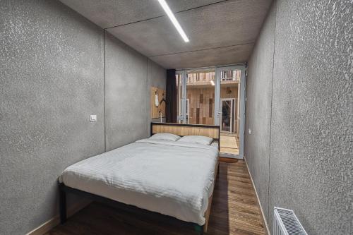 Cama pequeña en habitación con ventana en ИксаОтель, en Shymkent