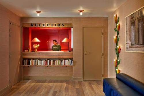 eine Person in einem Spiegel in einem Zimmer mit Büchern in der Unterkunft Hôtel de La Boétie in Paris