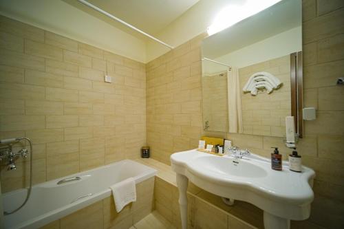 a bathroom with a sink and a bath tub and a sink at Kipi Mountain Resort in Kipoi