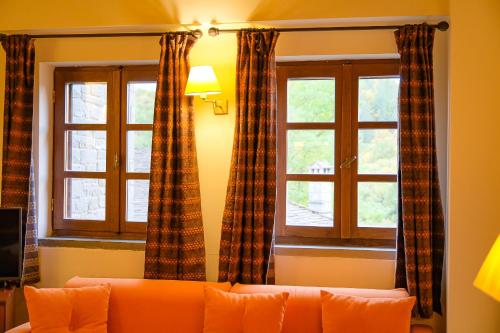 a living room with a couch and two windows at Kipi Mountain Resort in Kipoi