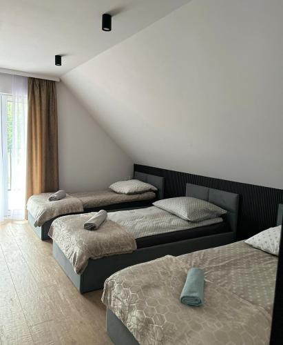 a room with three beds in a room at Leśne Wzgórze Apartamenty in Korbielów