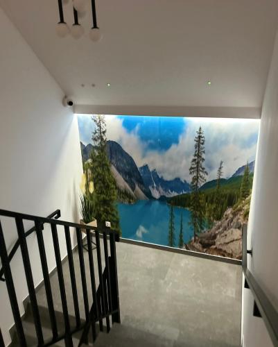 a wall mural of a mountain lake on a wall at Leśne Wzgórze Apartamenty in Korbielów