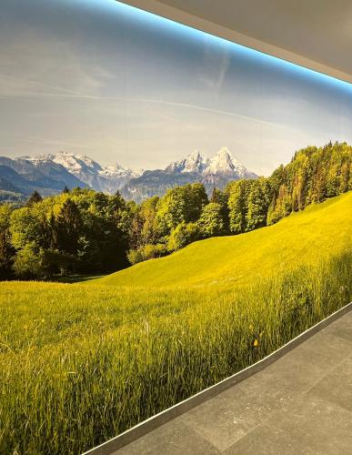 a painting of a green field with mountains in the background at Leśne Wzgórze Apartamenty in Korbielów
