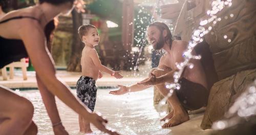 een man en een jongen die in een fontein spelen bij MT. OLYMPUS WATER PARK AND THEME PARK RESORT in Wisconsin Dells