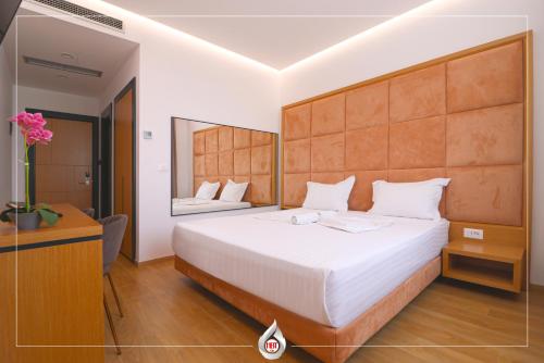 1 dormitorio con 1 cama blanca grande y espejo en NBT Hotel Lac en Laç