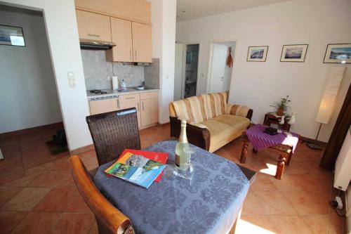 a living room with a dining table and a kitchen at Ferienwohnung Kutterfisch direkt im Stadthafen in Sassnitz