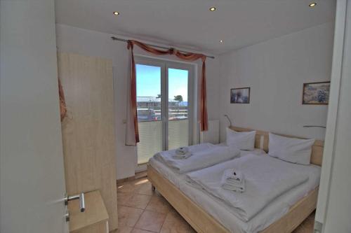 a bedroom with a large bed and a window at Ferienwohnung Kutterfisch direkt im Stadthafen in Sassnitz
