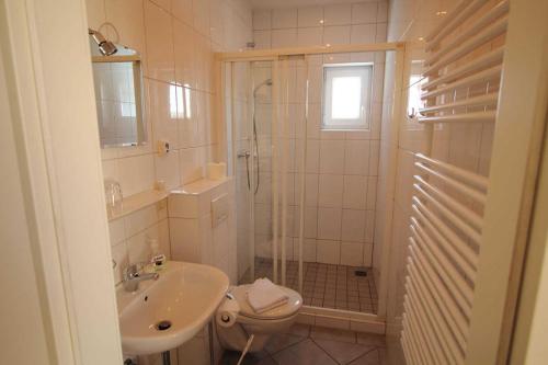 a bathroom with a shower and a toilet and a sink at Ferienwohnung Kutterfisch direkt im Stadthafen in Sassnitz