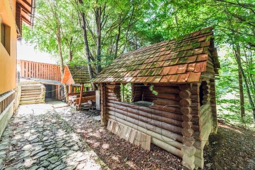 a log cabin with a roof on the side of a house at ПІД МАГУРОЮ in Pilipets