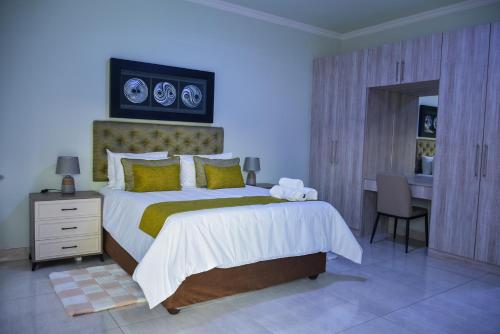 哈博罗内KAY'S TWO-BED SELFCATERING APARTMENT@21211的一间带大床和书桌的卧室