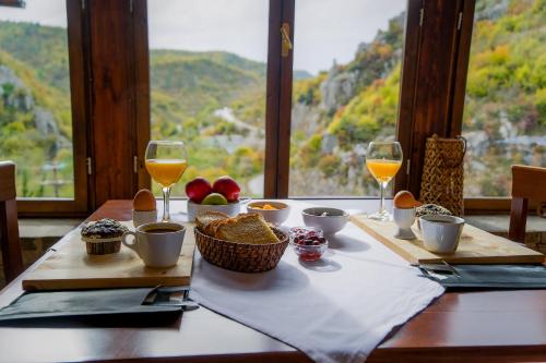 a table with glasses of wine and food on it at Kipi Mountain Resort in Kipoi