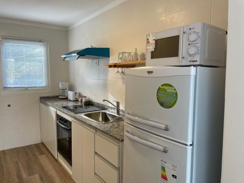 a kitchen with a white refrigerator and a sink at Amigos del Fin del Mundo in Ushuaia