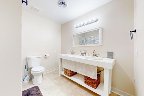 a white bathroom with a sink and a toilet at Easy Keel in Charleston