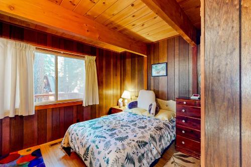 um quarto com uma cama com uma cómoda e uma janela em Tranquil Treehouse Haven em Tahoe City
