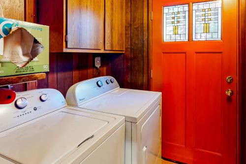 uma cozinha com uma máquina de lavar roupa e uma porta vermelha em Tranquil Treehouse Haven em Tahoe City