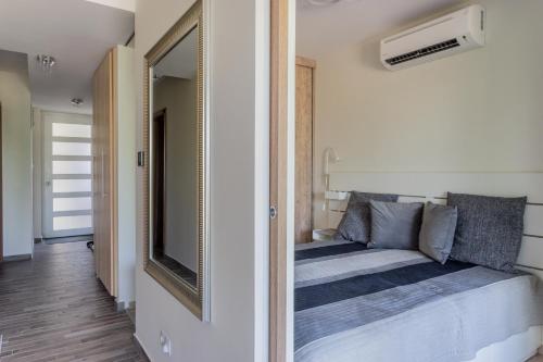- une petite chambre avec un lit et un miroir dans l'établissement LAKE MOMENTS - Pearl Apartment, à Balatonszemes