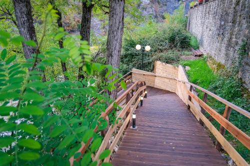 a wooden bridge in a park with trees at Kipi Mountain Resort in Kipoi