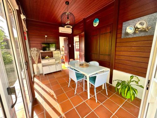 a kitchen with a table and chairs in a room at Bungalow Gaspardo , 2 chambres climatisées , à 2 mins à pied de la plage , wifi , jardin clos, parking ,sans vis-à-vis situé au Carbet in Le Carbet