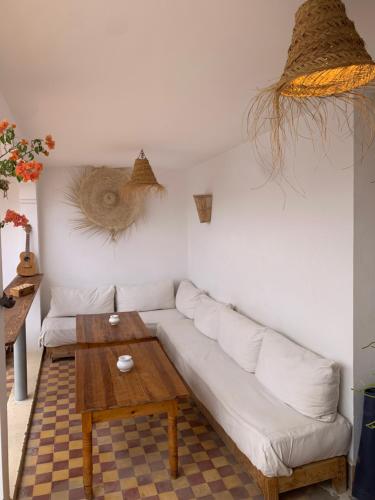 sala de estar con sofá blanco y mesa de madera en Riad Yu Yu, en Marrakech