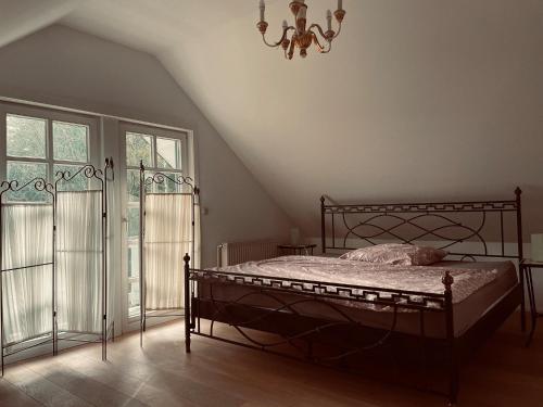 a bedroom with a bed and a chandelier at Vesta Waldhaus Bardowicker Heide in Bardowick