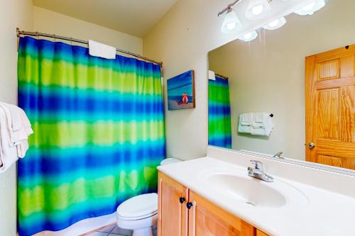 a bathroom with a sink and a shower curtain at Mermaid's Lair in Salvo