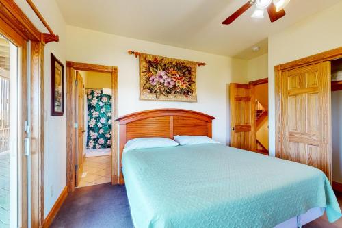 a bedroom with a bed with a blue comforter at Mermaid's Lair in Salvo