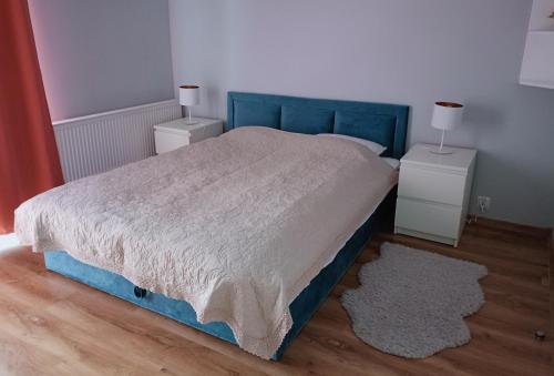 una camera con letto blu e due comodini di Apartament Olchowa Prestige 1 a Ustroń