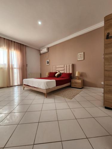 a bedroom with a bed and a tiled floor at Duplex bien equipe securise avec jardin et veranda in La Marsa