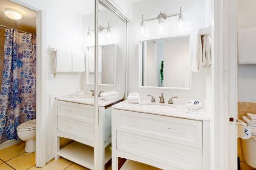 a white bathroom with a sink and a mirror at Delights in Daytona Unit 525 in Daytona Beach