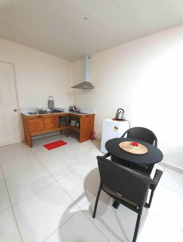 a kitchen with a table and chairs in a room at Wolfgramm Beachfront Motel in Utungake